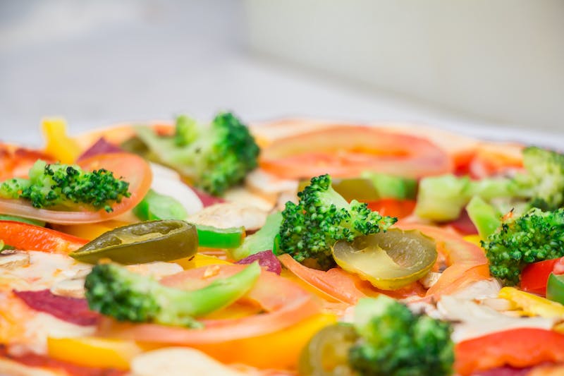 Assorted fresh pizza toppings spread on a wooden board